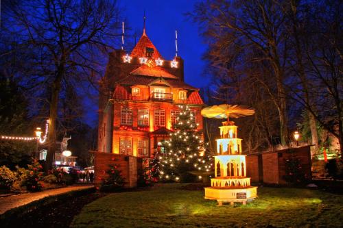 a house with a christmas tree in front of it at Hotel Seeschwalbe in Cuxhaven