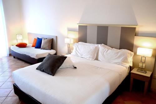 a hotel room with two beds and two lamps at Hotel Gajeta in Gaeta