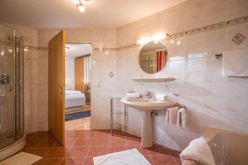 a bathroom with a sink and a shower and a mirror at Appartements Schwaighofer in Kössen