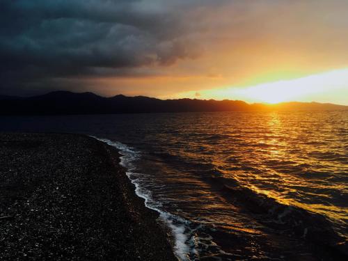a sunset on the shore of the ocean at Hotel Restaurant L'Europe in Saint-Florent
