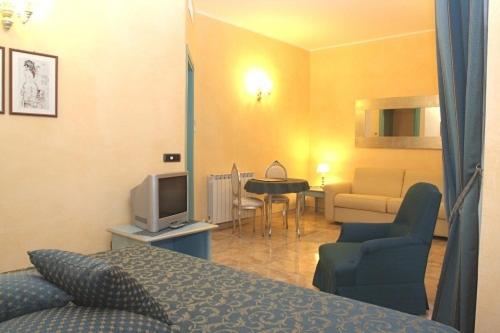a room with a bed and a living room with a tv at Da ö Vittorio SRL in Recco