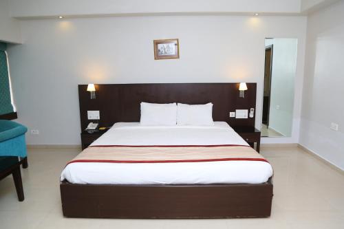 a bedroom with a large bed with a wooden headboard at The Curzon Court in Bengaluru