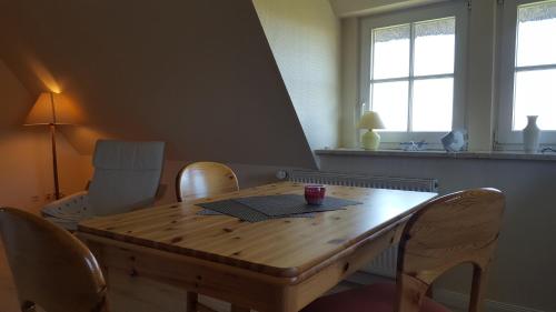 - une table à manger avec des chaises et une table en bois dans l'établissement Ferienwohnung Goting Nr.3, à Goting