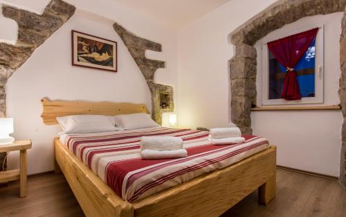 sypialnia z dużym łóżkiem w pokoju z oknem w obiekcie Holiday Home Eredità w Krku