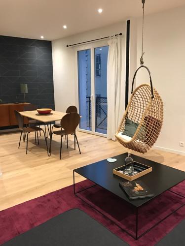 ein Wohnzimmer mit einem Tisch und einem Schaukelstuhl in der Unterkunft Le Luciole in Marseille