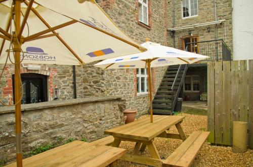 a picnic table and an umbrella in front of a building at The Red Lion in Knighton