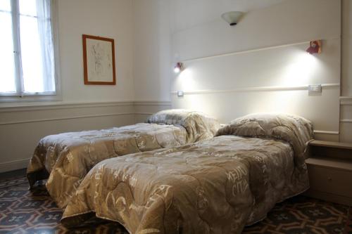 ヴェローナにあるMax Apartmentのベッド2台が隣同士に設置された部屋です。