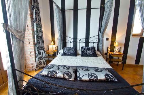 a bedroom with a black bed with blue pillows at Posada La Fabula in Santillana del Mar