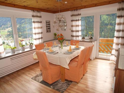 a dining room with a table and chairs and windows at Ferienwohnung Brennseeblick in Feld am See