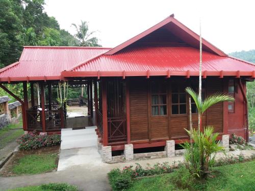 a small wooden house with a red roof at Highland Resort & Nature Tours in Tomohon