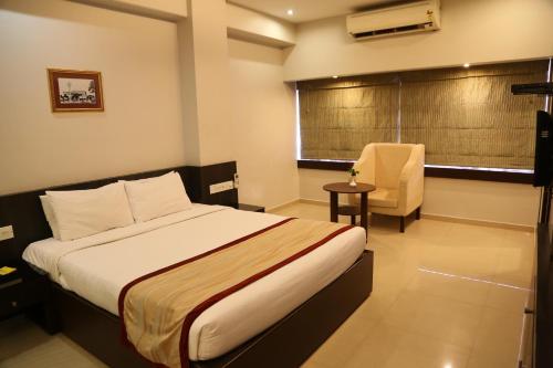 バンガロールにあるThe Curzon Courtのベッドと椅子付きのホテルルーム