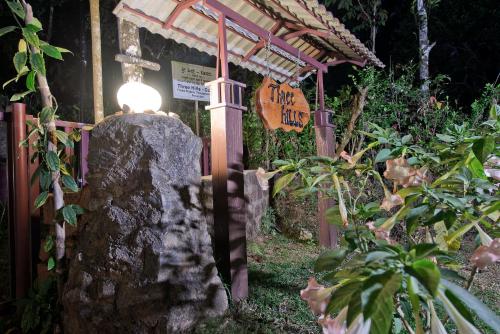 una linterna sobre una roca en un jardín por la noche en Three Hills Resort Coorg, en Madikeri