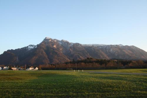 a large field with a mountain in the background at Vor den Toren Salzburgs in Wals