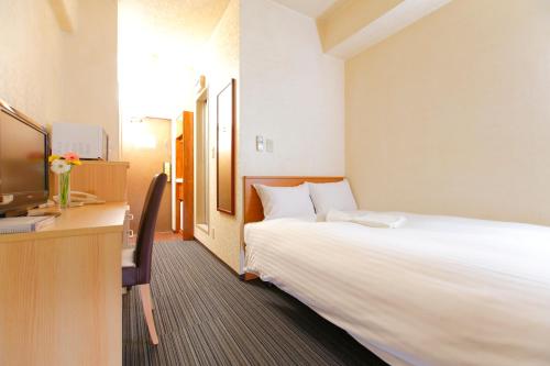 Habitación de hotel con cama grande y escritorio. en FLEXSTAY INN Tokiwadai en Tokio