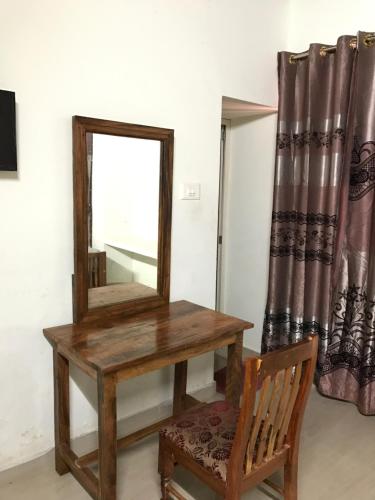 a dressing table with a mirror and a chair at Palm Rivera Kochi in Cochin
