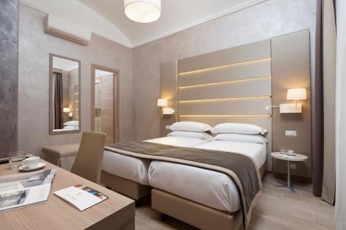 ローマにあるJackie's Apartmentsの大きなベッドとテーブルが備わるホテルルームです。