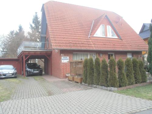 a red brick house with a car parked in the driveway at Tor zum Darss in Pruchten