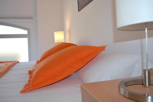 an orange pillow sitting on top of a bed at Enginyapartaments in Figueres