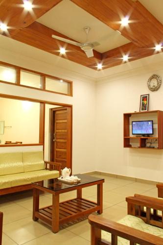 a living room with a couch and a tv at Coorg Rahul Villa- 3 Deluxe Bedrooms in Madikeri