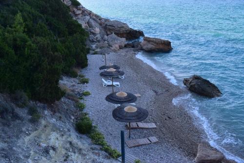 a group of umbrellas and chairs on a beach at Villa Eugenia in Theológos