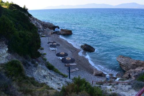 a group of umbrellas and chairs on a beach at Villa Eugenia in Theológos