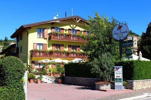 un gran edificio amarillo con un cartel delante en Hotel Romantic en Cavaion Veronese