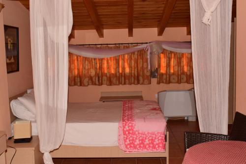 a bedroom with a bed and a window with curtains at Villa Eugenia in Theológos