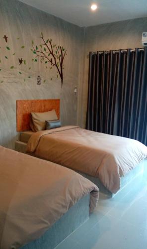 two beds sitting next to each other in a bedroom at Phurang Hill Resort in Kanchanaburi