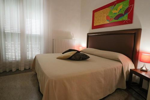 um quarto com uma cama com duas almofadas em Palazzo De Tomasi B&B em Gallipoli