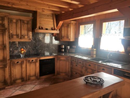 eine Küche mit Holzschränken und einem Holztisch in der Unterkunft Chalet Pétérets in Samoëns