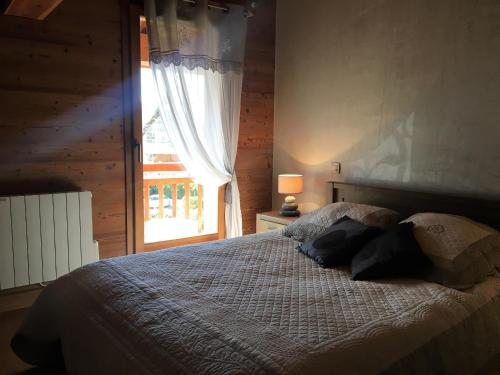 Chalet Clos Moccand في ساموان: غرفة نوم مع سرير مع نافذة وسرير سيد