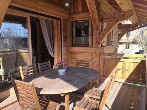 einen Holztisch und Stühle auf der Veranda einer Hütte in der Unterkunft Chalet Clos Moccand in Samoëns