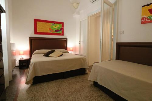 a bedroom with two beds and two lamps in it at Palazzo De Tomasi B&B in Gallipoli
