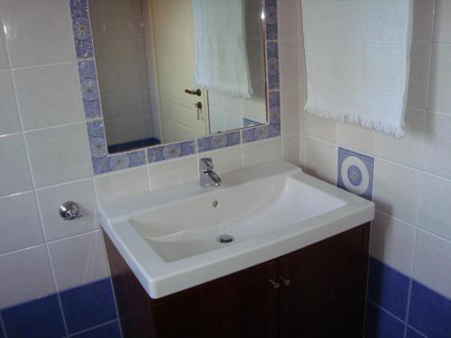 a bathroom with a white sink and a mirror at Wide sea Maisonette in Agios Dimitrios