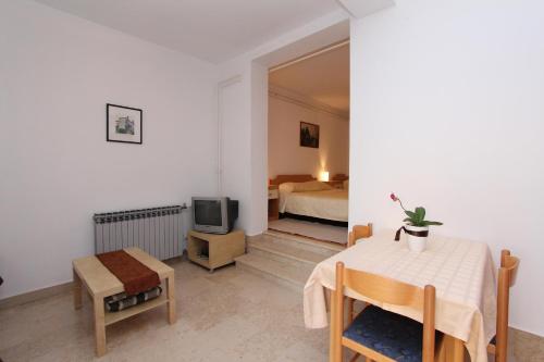 Pokój z łóżkiem, stołem i telewizorem w obiekcie Apartments Sturago w Rovinj