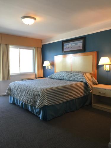 1 dormitorio con 1 cama grande y paredes azules en Royal Atlantic Beach Resort, en Montauk