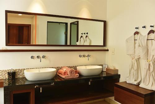 a bathroom with two sinks and a large mirror at Villa The Flows at Belle Rivière in Bel Ombre