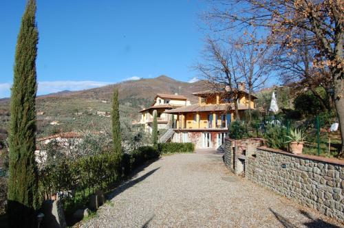 a house with a stone wall next to a driveway at Villa Lucrezia in Reggello