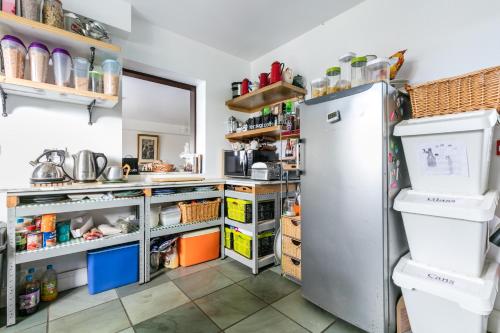 a kitchen with a refrigerator and shelves at Slemish Barn Hostel in Ballymena