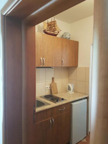 a kitchen with wooden cabinets and a sink at Apartments Montenegro Risan Čučković in Risan