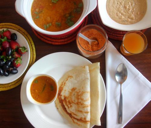 a table with a plate of food with soup and a sandwich at The Xanadu, Coonoor in Coonoor