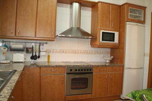 a kitchen with wooden cabinets and a stove top oven at Cal Riba in Llacuna