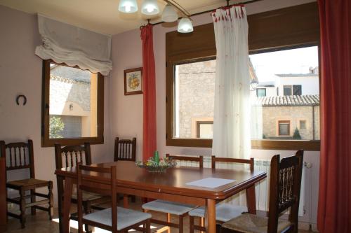 a dining room with a wooden table and chairs at Cal Riba in Llacuna