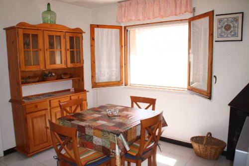 a dining room with a table and chairs and a window at Cal Riba in Llacuna