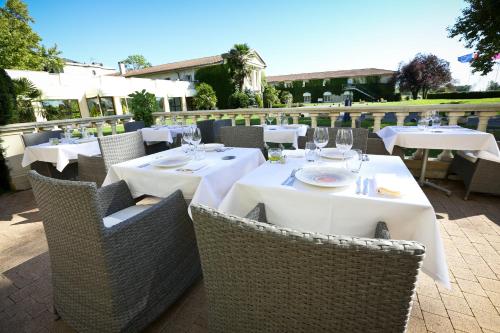 a hotel room with tables, chairs and umbrellas at Relais de Margaux - Hôtel & Spa in Margaux