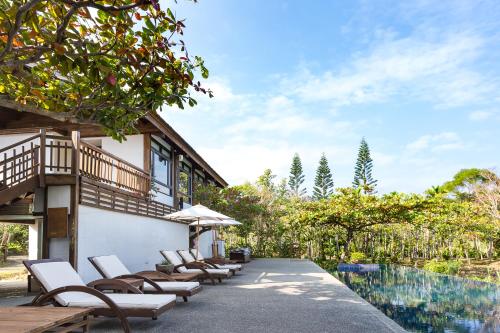 an outdoor patio with chairs and a swimming pool at Mudanwan Villa in Mudan