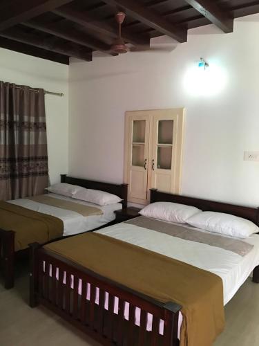 two beds sitting in a room with at Palm Rivera Kochi in Cochin