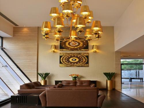 a living room with a couch and a chandelier at Majestic Court Sarovar Portico in Navi Mumbai