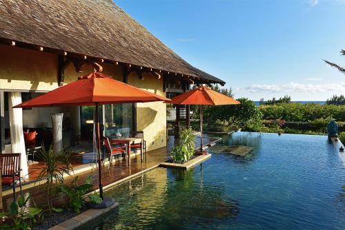 a resort with a swimming pool with umbrellas in the water at Villa The Flows at Belle Rivière in Bel Ombre