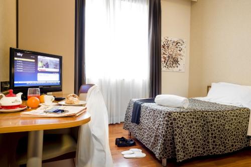 a bedroom with a desk with a computer and a bed at Hotel Ristorante Dragonara in San Giovanni Teatino